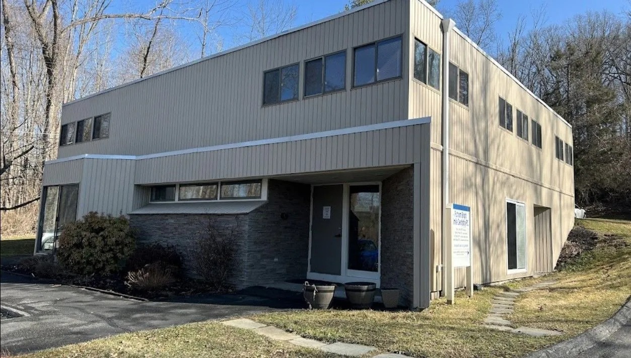 Exterior of the office building where the practice is located, with parking in front